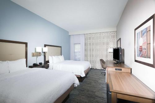 a hotel room with two beds and a television at Hampton Inn Mount Airy in Mount Airy