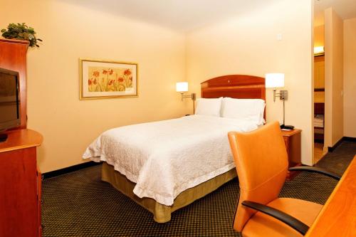 um quarto de hotel com uma cama e uma cadeira em Hampton Inn Montrose em Montrose