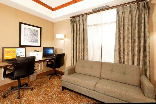 a living room with a couch and a desk with a computer at Hampton Inn by Hilton Montrose in Montrose