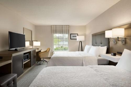 Hampton Inn & Suites Middletown في ميدلتاون: غرفة فندقية بسريرين وتلفزيون بشاشة مسطحة