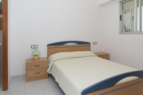 a bedroom with a bed and a lamp and a window at Orly, A-6-38 PK 125 in Cullera