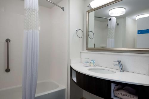 uma casa de banho com um lavatório, um espelho e um chuveiro em Hampton Inn Myrtle Beach West em Myrtle Beach
