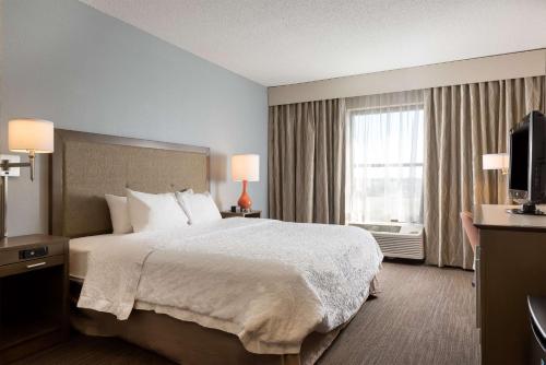 a hotel room with a large bed and a window at Hampton Inn Myrtle Beach West in Myrtle Beach