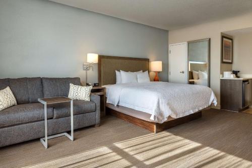 a hotel room with a bed and a couch at Hampton Inn Myrtle Beach West in Myrtle Beach