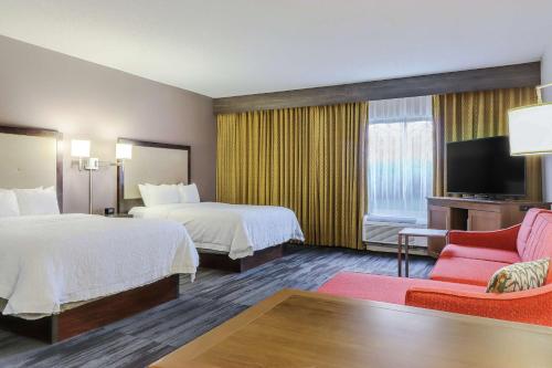 a hotel room with two beds and a flat screen tv at Hampton Inn Heath in Heath