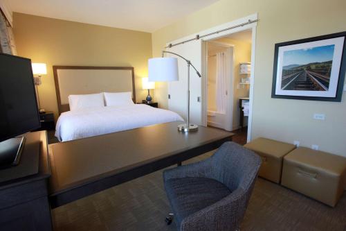 a hotel room with a bed and a desk with a chair at Hampton Inn & Suites Nampa at the Idaho Center in Nampa