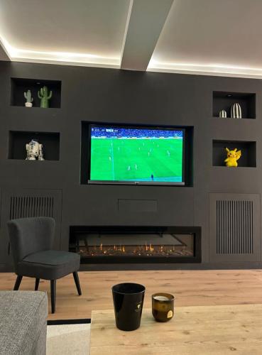 a living room with a television and a fireplace at Superbe T2 en plein coeur de Neuilly / Voie Privée in Neuilly-sur-Seine
