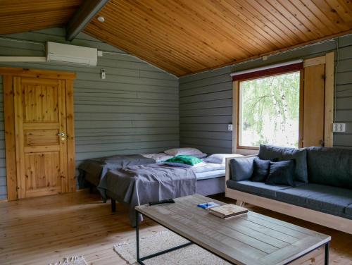 een woonkamer met een bank en een tafel bij Tenon maisemamökit in Utsjoki