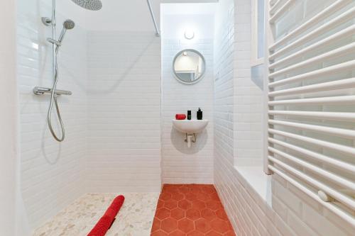 y baño blanco con lavabo y ducha. en Charmant F1 dans la veille ville en Ajaccio