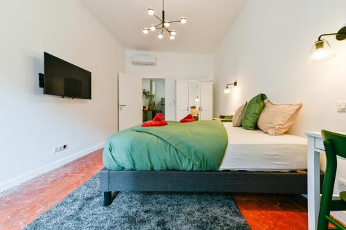 1 dormitorio con 1 cama y TV de pantalla plana en Charmant F1 dans la veille ville en Ajaccio