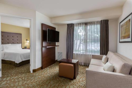 une chambre d'hôtel avec un lit et un canapé dans l'établissement Homewood Suites by Hilton Newark Fremont, à Fremont