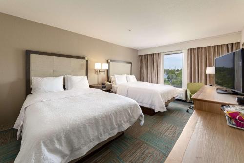 um quarto de hotel com duas camas e uma televisão de ecrã plano em Hampton Inn Niceville-Elgin Air Force Base em Niceville