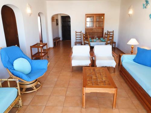 un soggiorno con mobili bianchi e blu e un tavolo di Albufeira Apart AE - Sea & Old Town View ad Albufeira
