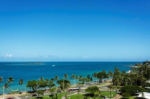 a view of the ocean and a city with palm trees at Hilton Noumea La Promenade Residences in Noumea
