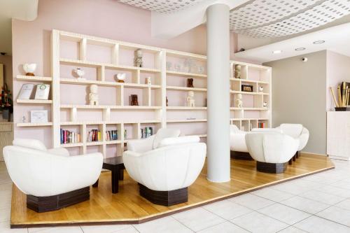 a library with white chairs and bookshelves at Hilton Noumea La Promenade Residences in Noumea