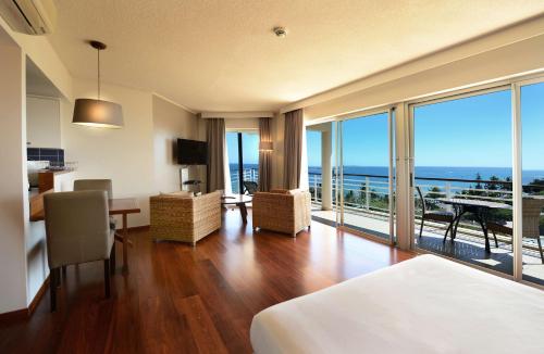 Hilton Noumea La Promenade Residences في نومْيا: غرفة فندقية مطلة على المحيط