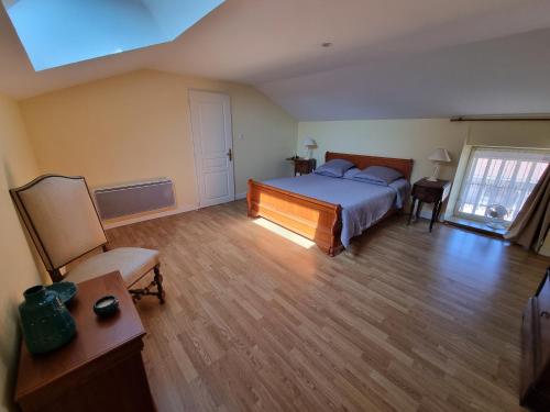 ein Schlafzimmer mit einem Bett und einem Stuhl darin in der Unterkunft Tanzanite - 6 couchages in Archigny