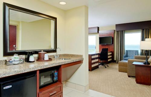 Habitación de hotel con lavabo y sala de estar. en Hampton Inn & Suites Ocean City en Ocean City