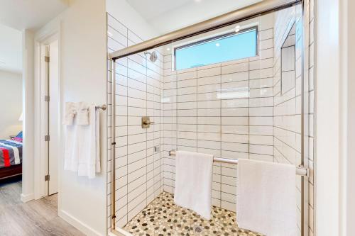 a bathroom with a shower with white tiles at Desert Oasis in Prescott Valley