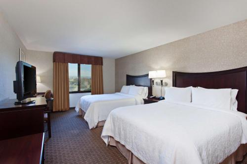 アラメダにあるHampton Inn & Suites Oakland Airport-Alamedaのベッド2台、薄型テレビが備わるホテルルームです。