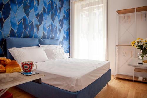 1 dormitorio con 1 cama con pared azul en Sea Glimpse Studio - Santa Lucia, en Nápoles