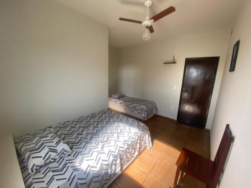 um quarto com uma cama e uma ventoinha de tecto em Hotel Lilía em Uberlândia