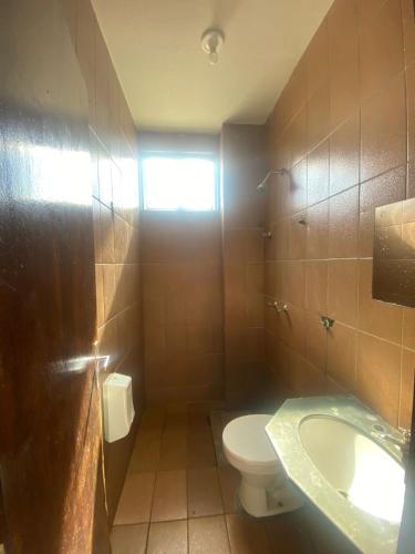 a bathroom with a toilet and a sink at Hotel Lilía in Uberlândia