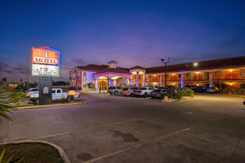 a motel with cars parked in a parking lot at night at Casa Rosa Inn in Port Isabel