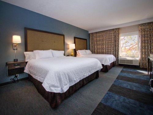 a hotel room with two beds and a window at Hampton Inn Edmond in Edmond