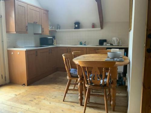 een keuken met een houten tafel en stoelen bij The Granary Cottage in Burrington