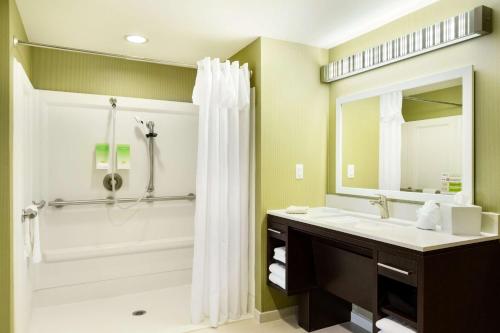 y baño con bañera, lavamanos y ducha. en Home2 Suites By Hilton Omaha West, en Omaha