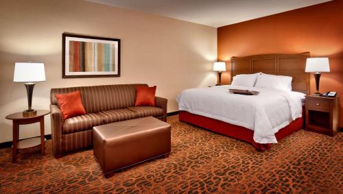 a hotel room with a bed and a couch at Hampton Inn Omaha/West Dodge Road, Old Mill in Omaha