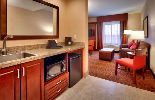 a kitchen with a sink and a living room at Hampton Inn Omaha/West Dodge Road, Old Mill in Omaha