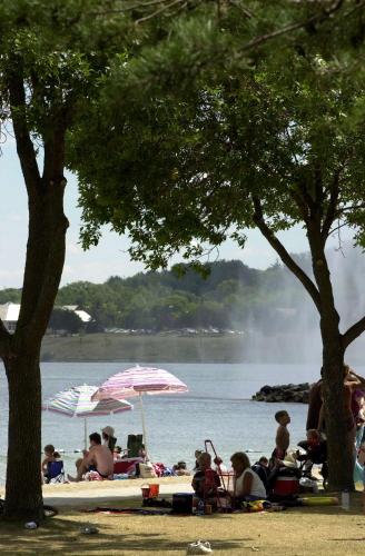 a group of people sitting on a beach with umbrellas at Hampton Inn & Suites by Hilton Barrie in Barrie
