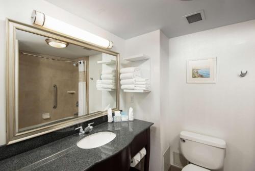 a bathroom with a sink and a toilet and a mirror at Hampton Inn & Suites by Hilton Barrie in Barrie