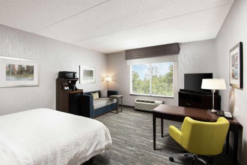 a hotel room with a bed and a desk and a chair at Hampton Inn & Suites by Hilton Barrie in Barrie