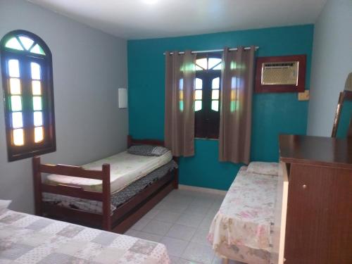 a room with two beds and two windows in it at Recanto do Farol in Salinópolis
