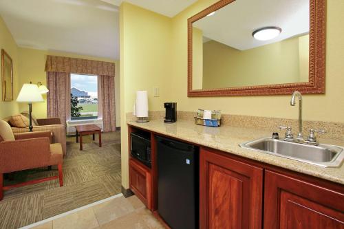 a kitchen with a sink and a living room at Hampton Inn & Suites Murray in Murray