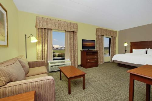 Habitación de hotel con cama, sofá y TV en Hampton Inn & Suites Murray, en Murray