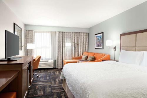 a hotel room with a bed and a television at Hampton Inn Paris in Paris