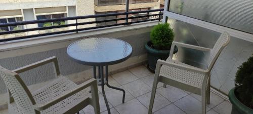 a table and two chairs on a balcony at El Greco in Patra