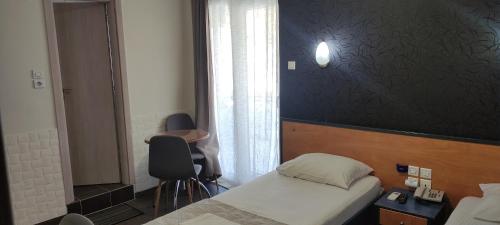 niewielka sypialnia z łóżkiem i oknem w obiekcie El Greco w mieście Patras