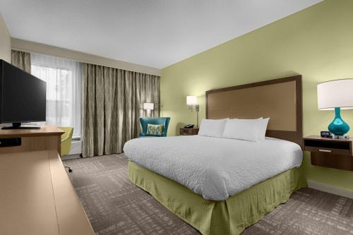 a hotel room with a bed and a flat screen tv at Hampton Inn Pawleys Island in Pawleys Island