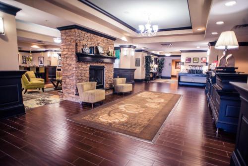 a living room with a fireplace and a living room with a rug at Hampton Inn - Monticello in Monticello