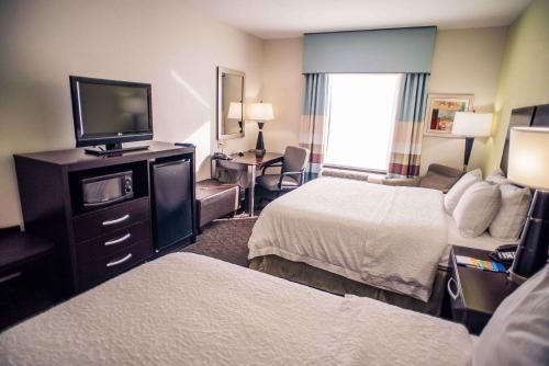 a hotel room with two beds and a flat screen tv at Hampton Inn - Monticello in Monticello