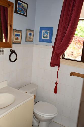a bathroom with a toilet and a red curtain at Triple Room Bed and Breakfast main House in Guillet