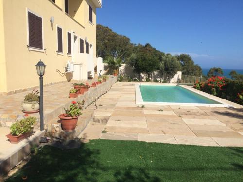 a house with a swimming pool next to a building at Cala Arenella in Sciacca