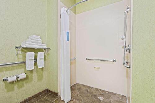 a bathroom with a shower with white towels at Hampton Inn West Palm Beach-Lake Worth-Turnpike in Lake Worth