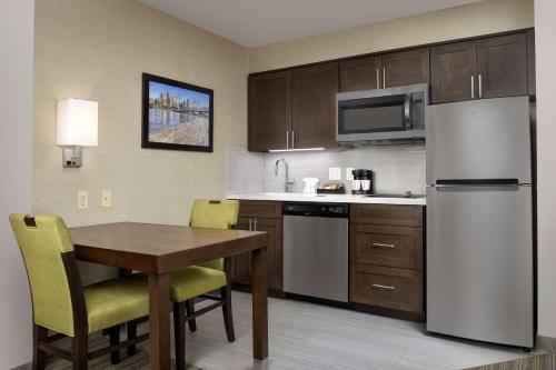 a kitchen with a table and a refrigerator at Homewood Suites Hillsboro Beaverton in Beaverton