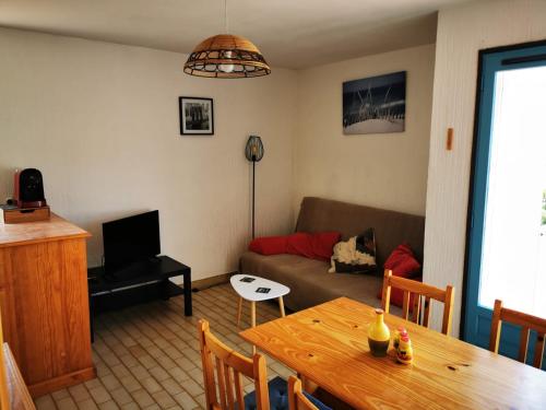 ein Wohnzimmer mit einem Tisch und einem Sofa in der Unterkunft Charmant T2 climatisée au coeur du village in Saint-Mandrier-sur-Mer